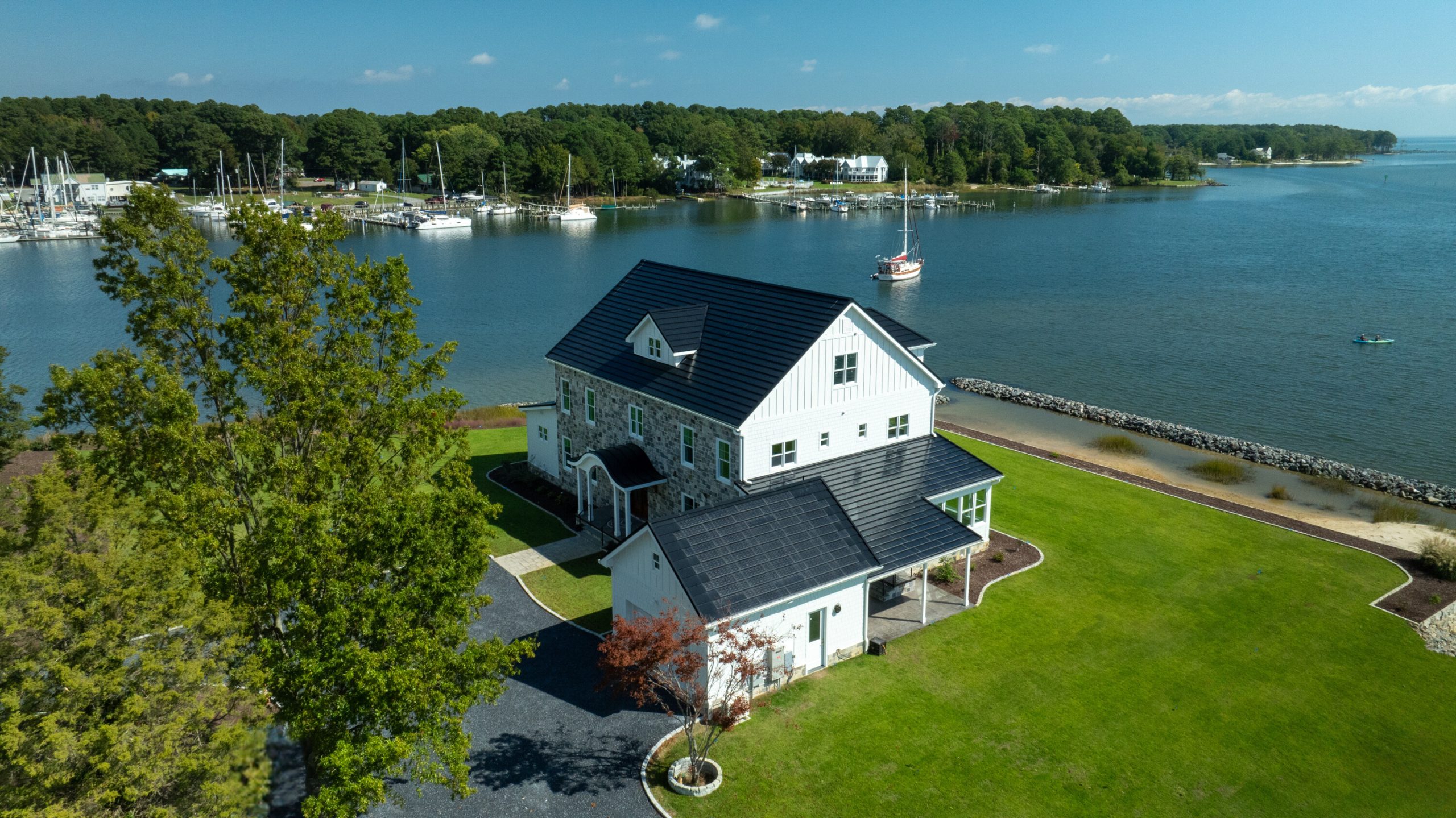 ICF Homes of Virginia Deltaville project side profile showing the solar panels on the roof of the garage and the view of the marina