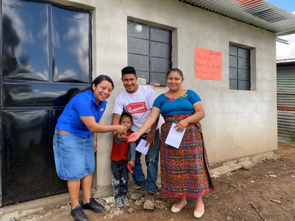 A small family standing in front of their new home that was donated by ICF Homes of Virginia.