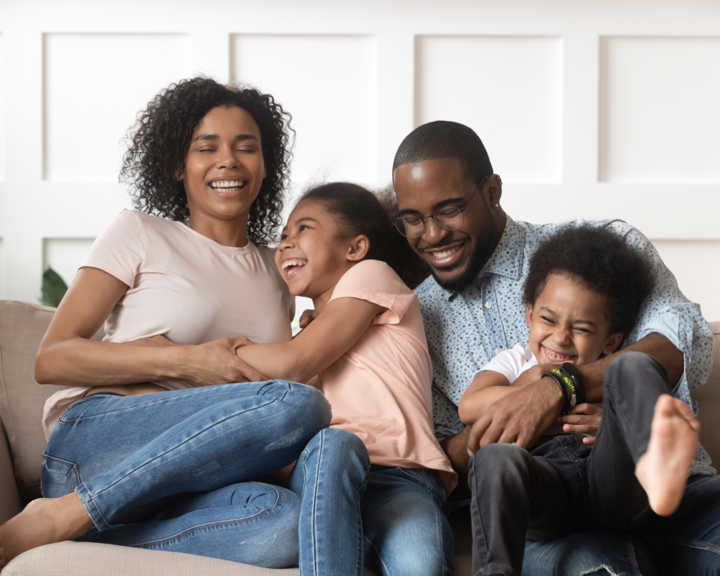 A family laughing and cuddling on a couch