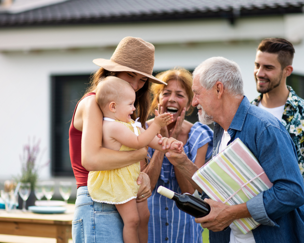 A multi generational family is surrounding an excited baby.